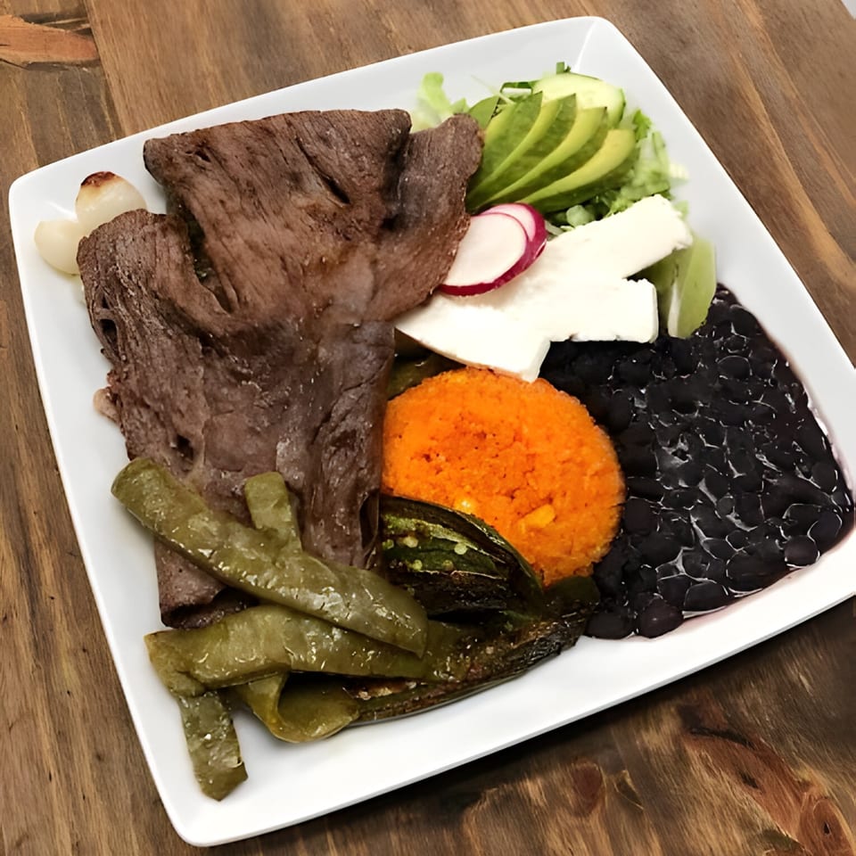 El Agave Mexican Cuisine's carne asada plate with rice, black beans, grilled peppers, and avocado.